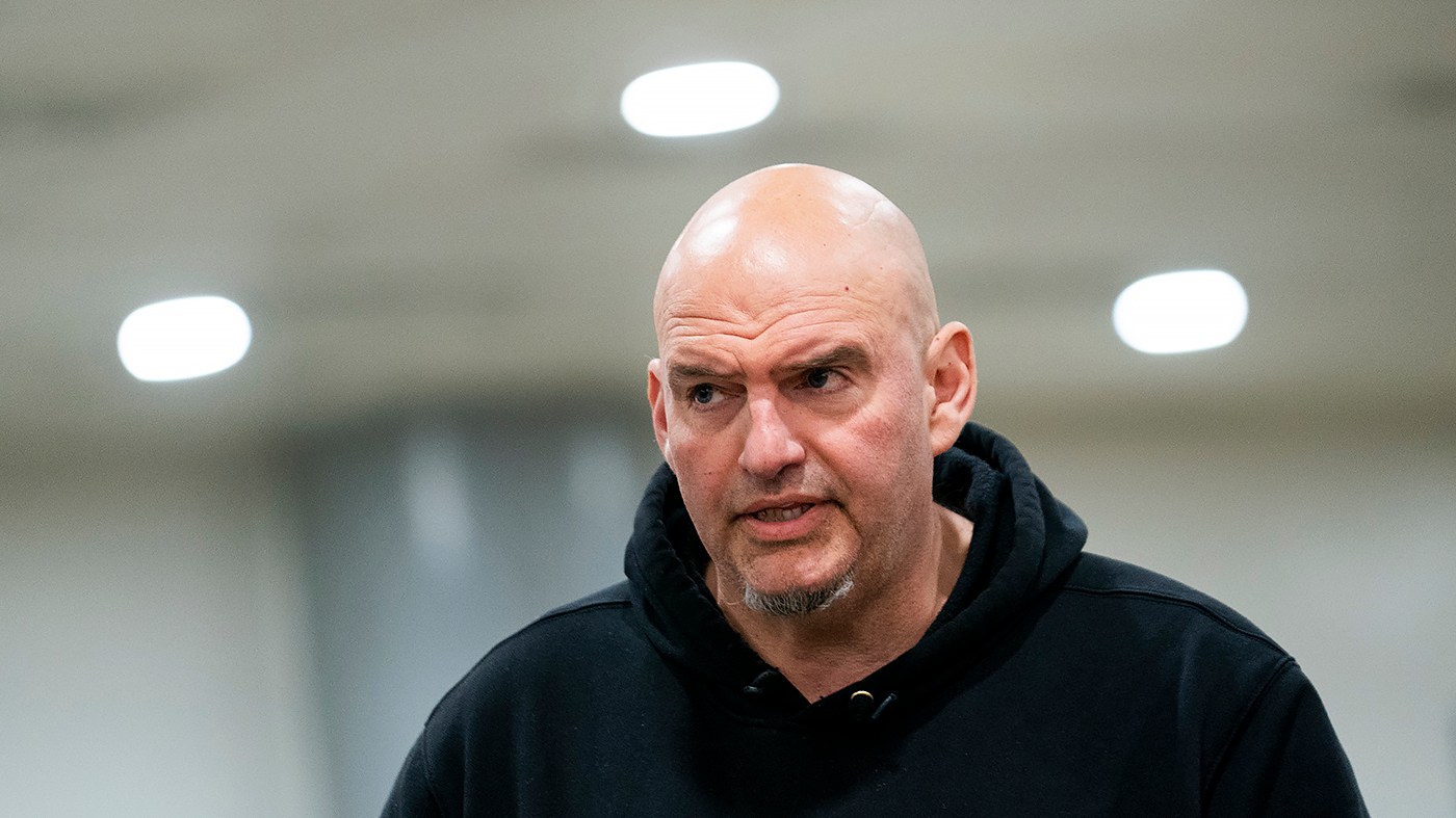 Sen. John Fetterman (D-Pa.) speaks to a reporter as he leaves the Capitol following a procedural vote regarding an IRS rule on March 25, 2026.