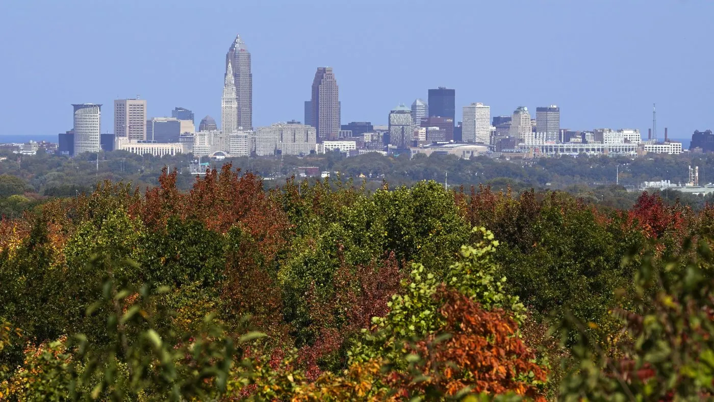 Downtown Cleveland is seen above the colorful foliage of West Creek Reservation in Parma, Ohio, Sunday, Oct. 16, 2022. (AP Photo/Sue Ogrocki)