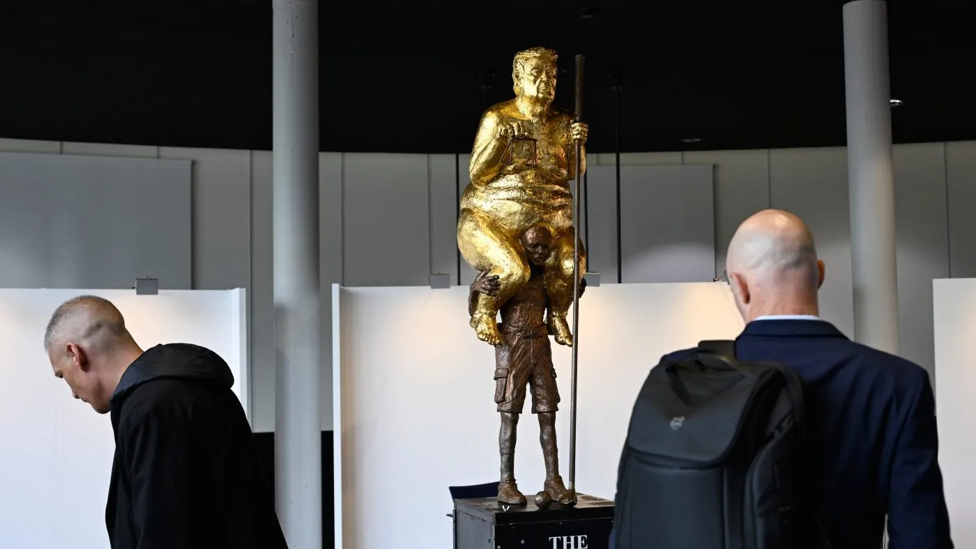 Visitors looks at a scupture titled “The Orange Plague” by Danish artist Jens Galschiot, depicting U.S. President Donald Trump, on display at the European Parliament building in Strasbourg, France, Wednesday Oct. 7, 2026. (AP Photo/Pascal Bastien)