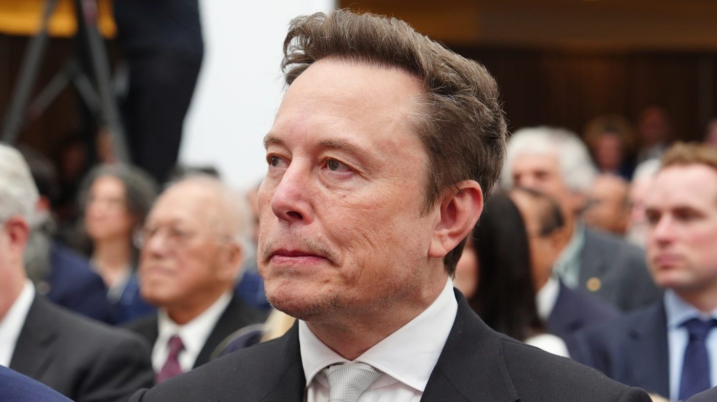 Elon Musk listens as President Donald Trump speaks during an event at the U.S. Institute of Peace, Thursday, Oct. 8, 2026, in Washington. (AP Photo/Julia Demaree Nikhinson)