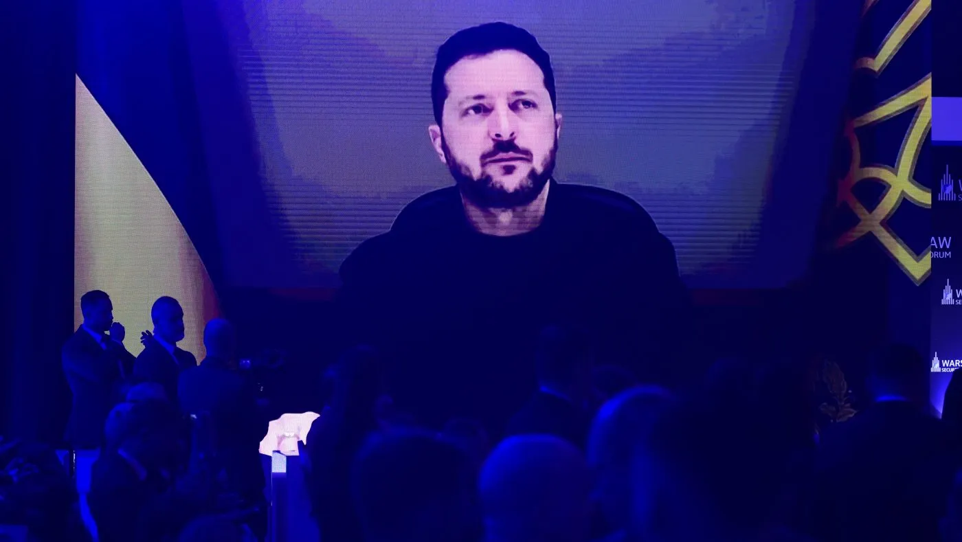 People watch Ukrainian President Volodymyr Zelensky on a large screen as he speaks to the Warsaw Security Forum in Warsaw, Poland, Oct. 12, 2026.