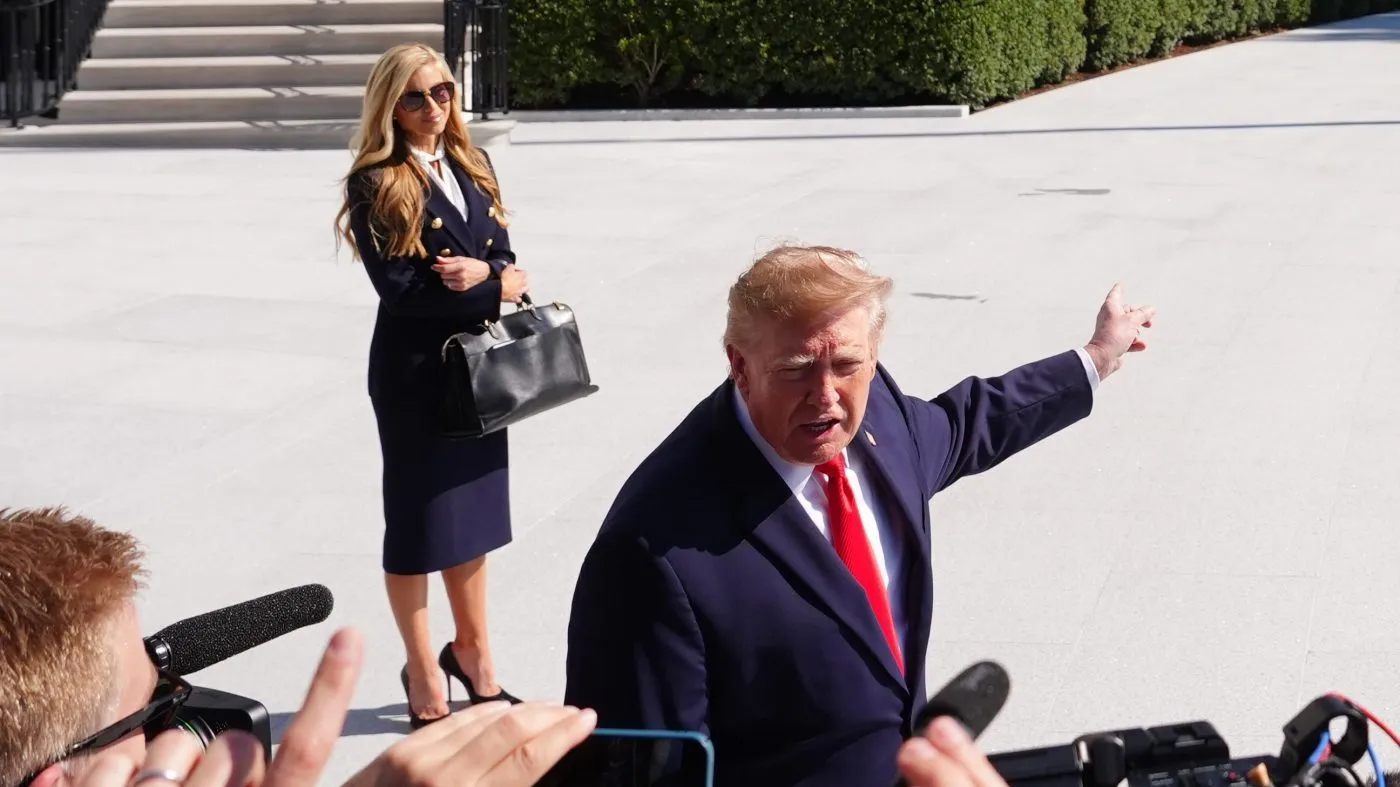 President Trump speaks to the reporters as he walks to board Marine One on the South Lawn of the White House, Oct. 13, 2026, in Washington, as White House press secretary Katie Zacharia looks on.