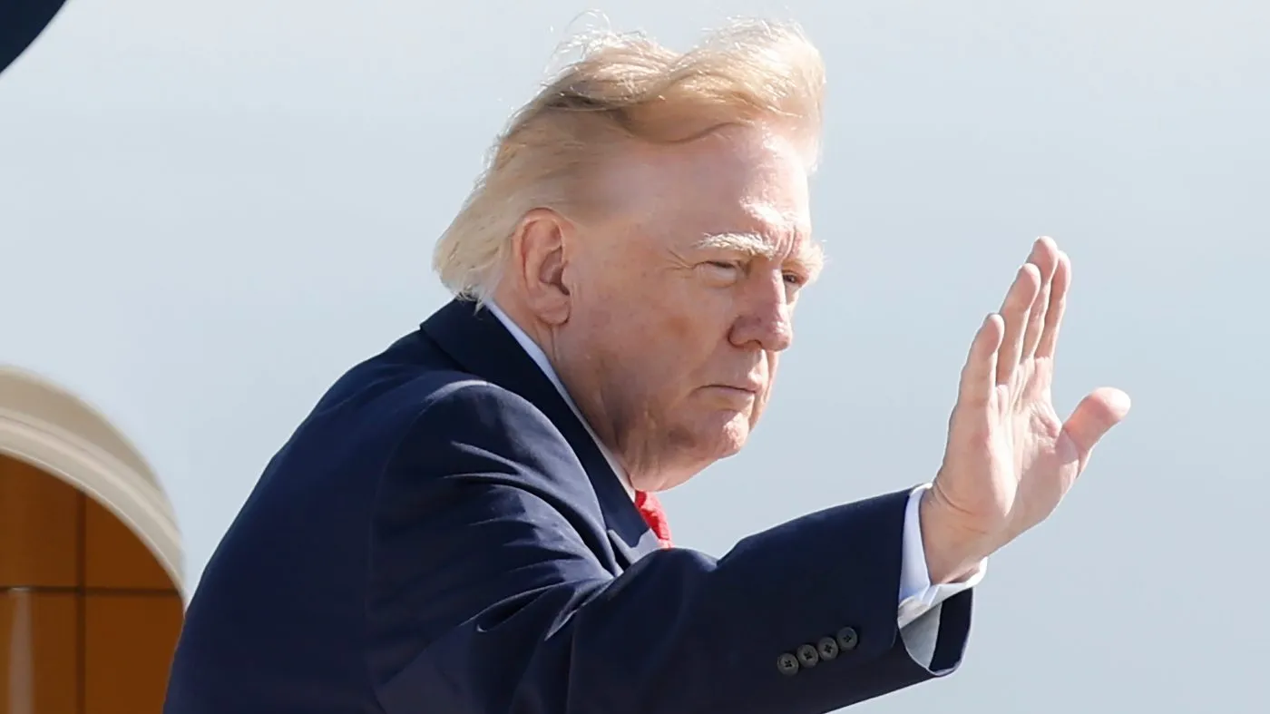 President Donald Trump waves as he boards Air Force One at Joint Base Andrews, Md., Tuesday, Oct. 13, 2026. (AP Photo/Luis M. Alvarez)