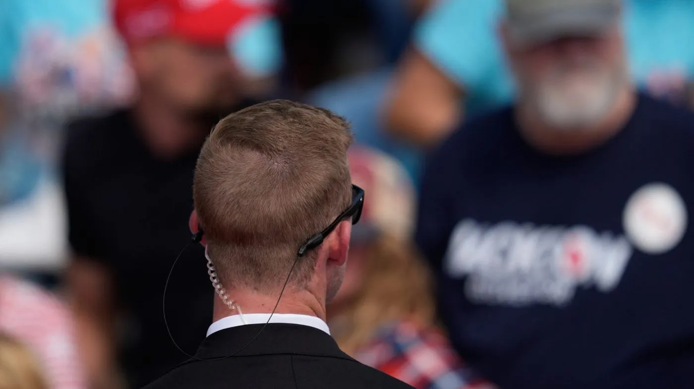 A U.S. Secret Service agent watches the crowd before President Donald Trump arrives at a campaign rally at Dalton Municipal Airport, Friday, October. 16, 2026, in Dalton Ga.