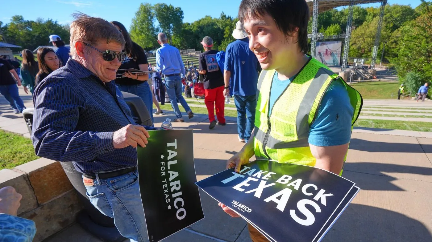 Volunteer Jason Stevens, right, hands out signs to supporters before a campaign event for Democratic U.S. Senate candidate Texas state Rep. James Talarico in Plano, Texas, Sunday, Oct. 18, 2026.