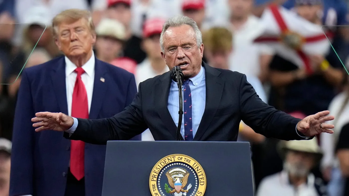 Health and Human Services Secretary Robert F. Kennedy Jr. speaks as President Donald Trump listens during a campaign rally, Friday, Oct. 23, 2026, at Alico Arena on the campus of Florida Gulf Coast University in Fort Myers, Fla. (AP Photo/Chris O’Meara)