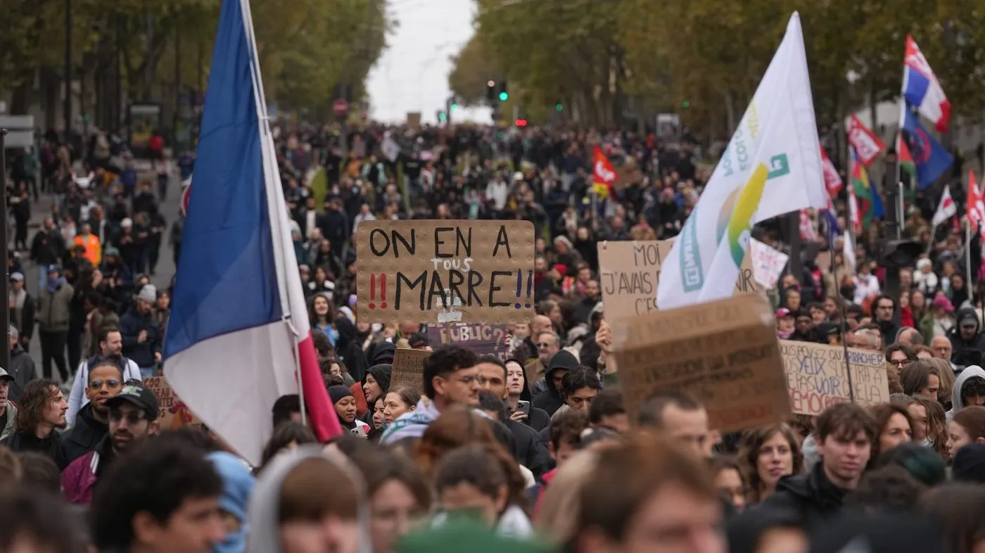 Protesters hold a sign reading “We are fed up” during a demonstration against rising living costs in Paris, Saturday, Oct. 24, 2026.