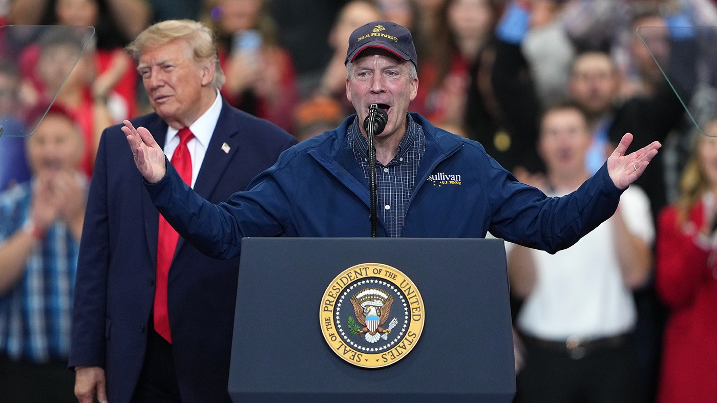 President Trump listens as Sen. Dan Sullivan (R-Alaska) speaks at a campaign rally at the Curtis D. Menard Memorial Sports Center, Oct. 13, 2026, in Wasilla, Alaska.