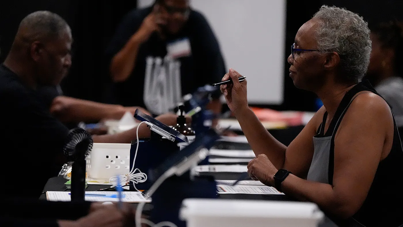 A voter works with election officials before voting at the Southwest Arts Center voting site on the first day for early voting in Georgia, Oct. 13, 2026, in Atlanta.