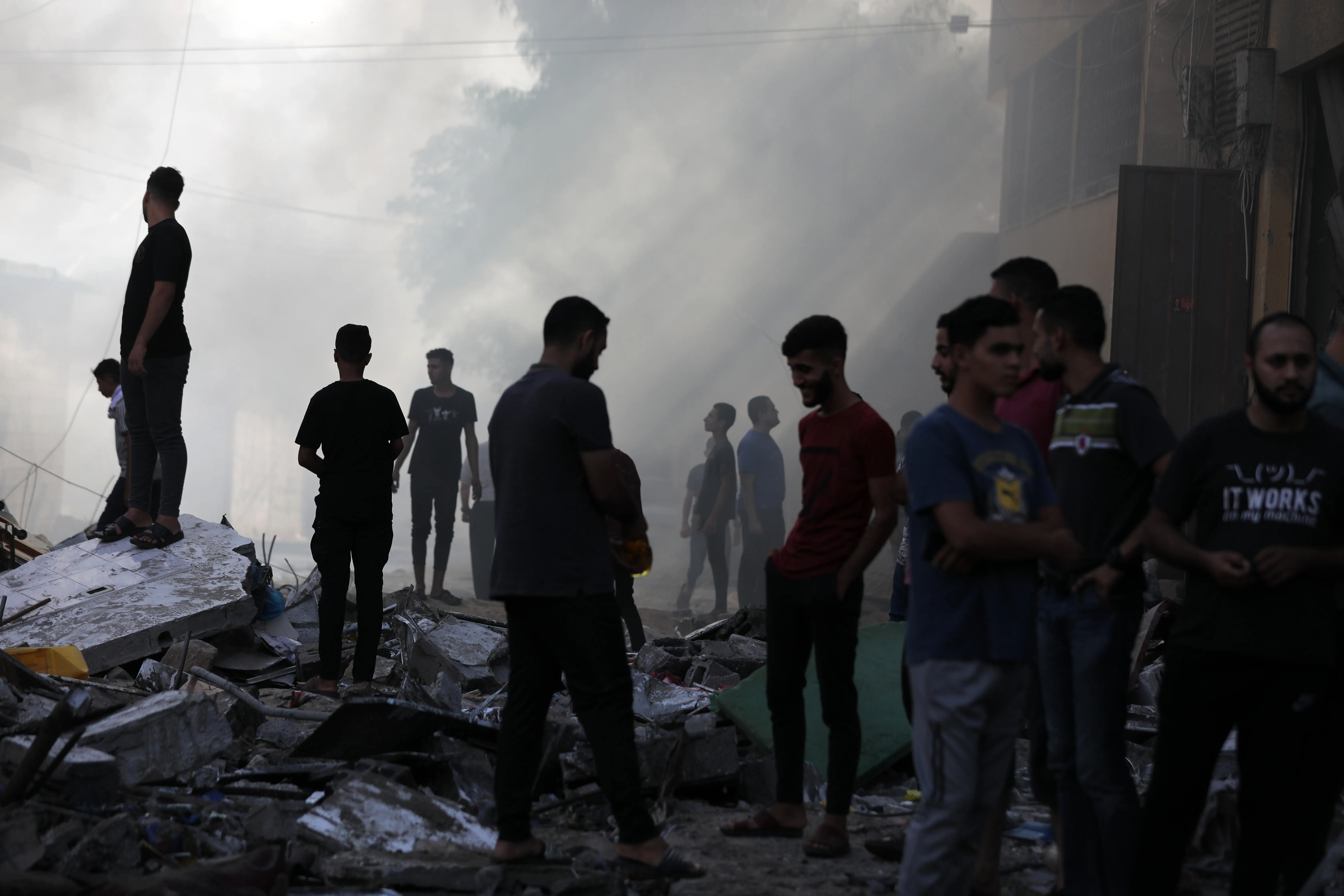 People assess the destruction cause by Israeli air strikes in Gaza City on October 7, 2023. Palestinian militants have begun a ”war” against Israel which they infiltrated by air, sea and land from the blockaded Gaza Strip, Israeli officials said, a major escalation in the Israeli-Palestinian conflict. (Photo by Majdi Fathi/NurPhoto via Getty Images)