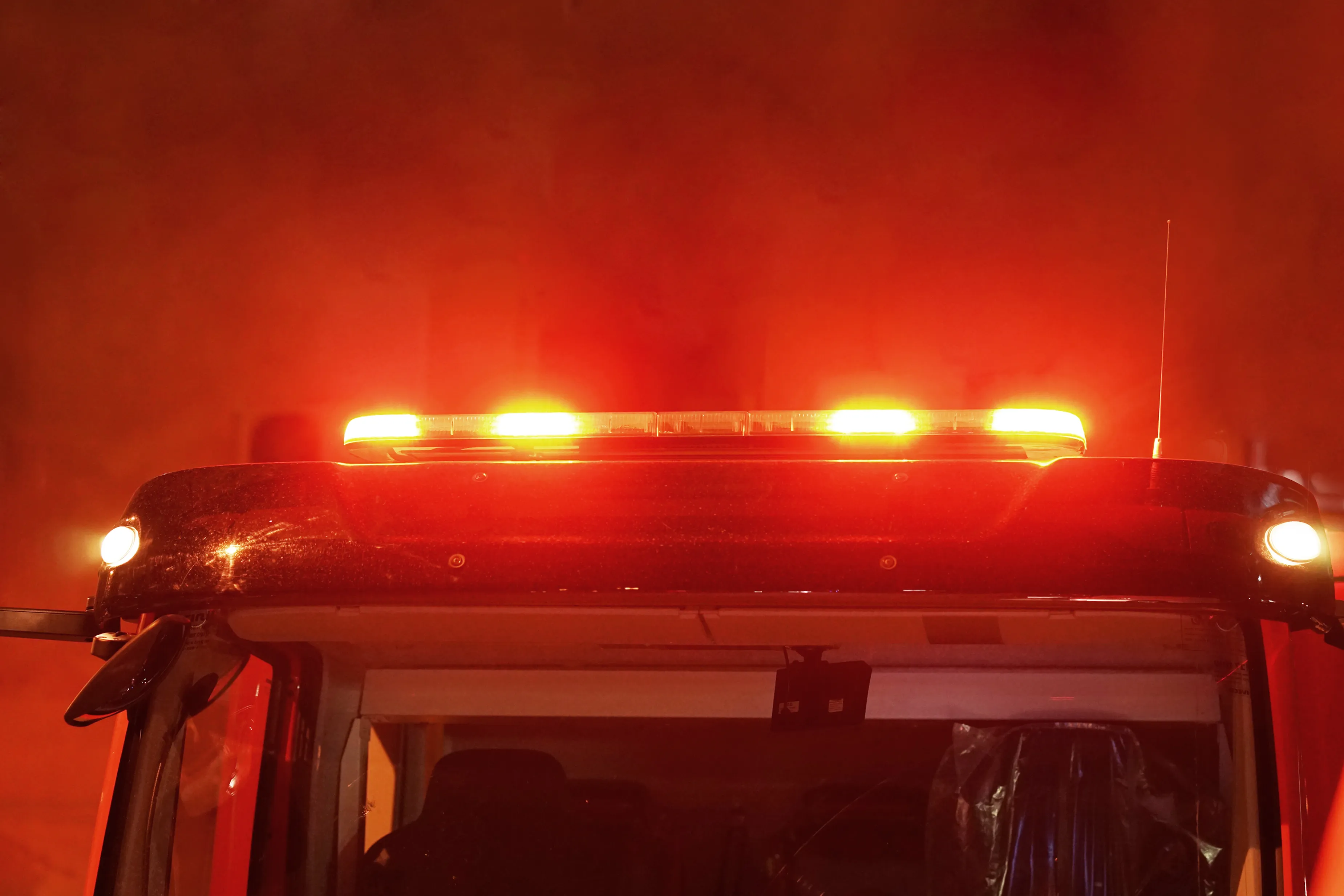Red lights of a fire engine. Night time. Fire engine. Extinguishing the fire. Close-up of the red lights on top of a fire engine.