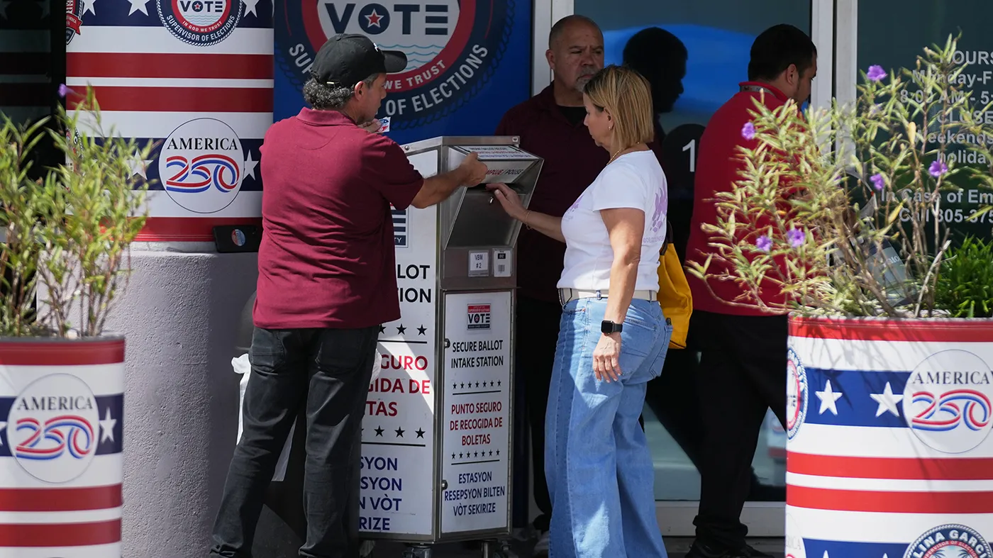 A person drops a vote-by-mail ballot in a secure ballot intake station at the Office of the Supervisor of Elections during early voting in the 2026 midterm elections on Oct. 27, 2026, in Doral, Fla.