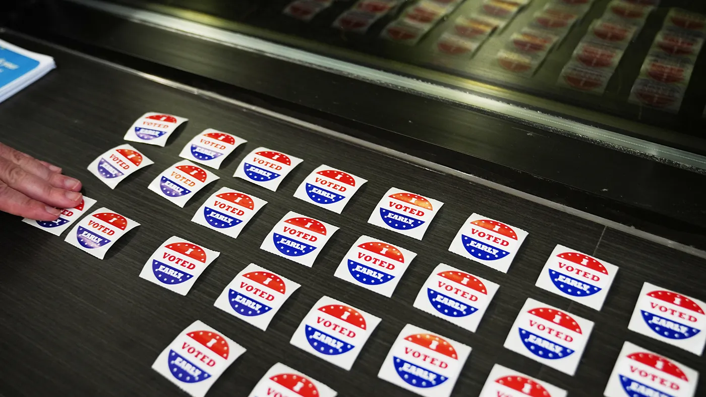 A voter takes a sticker after casting a ballot on the first day of early voting in Minnesota at the Elections & Voter Services building, Friday, Sept. 18, 2026, in Minneapolis.