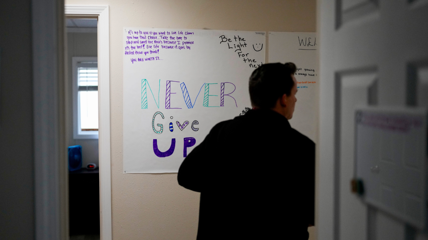 Dr. Jesse Davis, of the Lummi Healing Spirit opioid treatment program, walks by a sign with encouraging messages at their seven-bed facility on the Lummi Reservation, Thursday, Feb. 8, 2024, near Bellingham, Wash. (AP Photo/Lindsey Wasson)