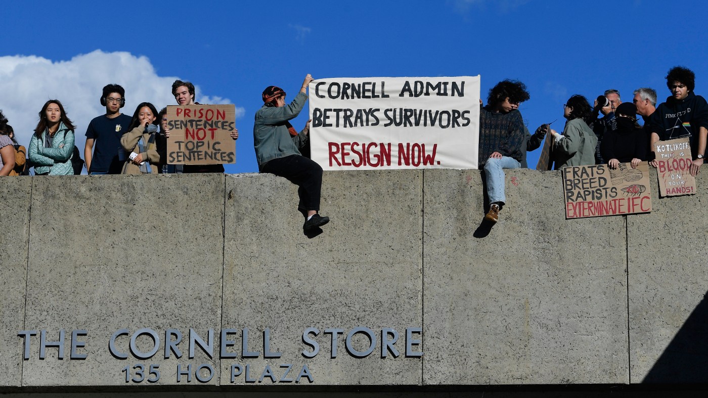 Attendees hold signs during a protest against Cornell University’s handling of the 2024 fraternity-house gang rape allegations at the university Monday, Oct. 5, 2026, in Ithaca, N.Y.