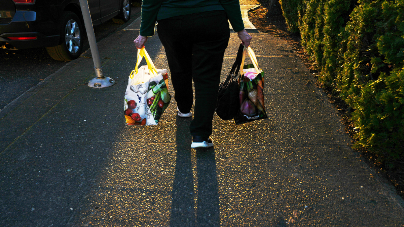 A woman carries reuable shopping bags to her car on Monday, March 16, 2026, in Portland, Ore. (AP Photo/Jenny Kane)