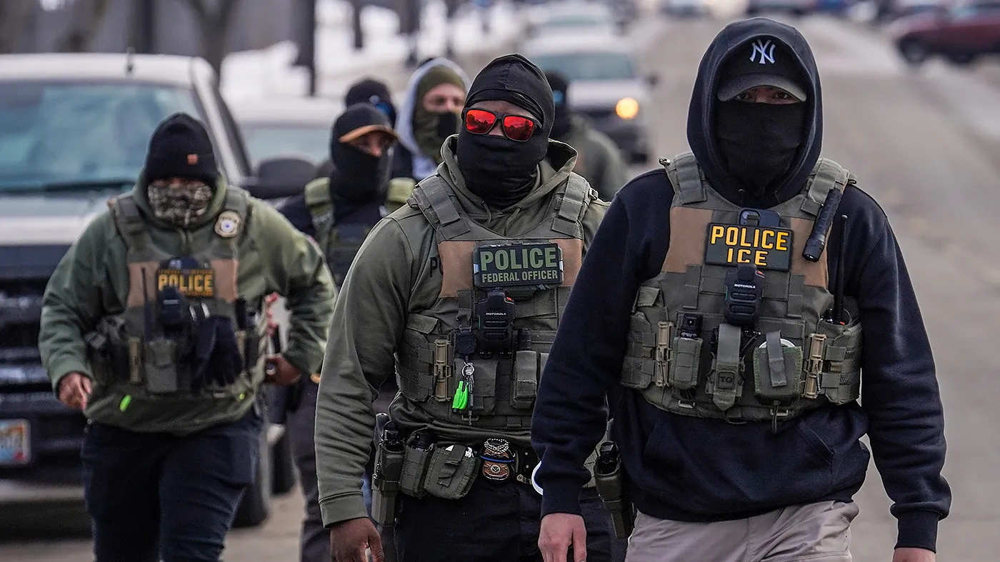 Federal agents walk down a street while conducting immigration enforcement operations in Minneapolis, Feb. 5, 2026.