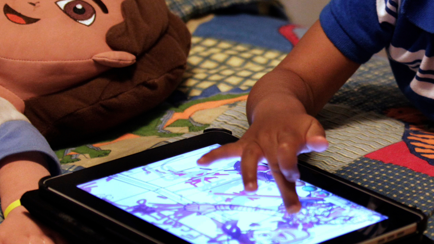FILE – In this Friday, Oct. 21, 2011, file photo, a child plays with an iPad in his bedroom. (AP Photo/Gerald Herbert, File)