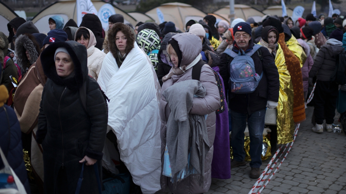 FILE – Refugees wait in a crowd for transportation after fleeing from the Ukraine and arriving at the border crossing in Medyka, Poland, March 7, 2022. (AP Photo/Markus Schreiber, File)