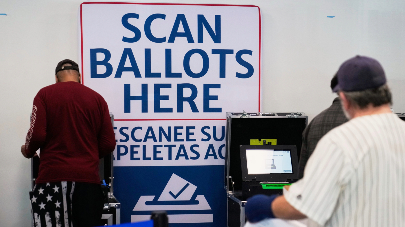 Voters scan their ballots at early in-person voting in Cleveland, Wednesday, Oct. 7, 2026. (AP Photo/Sue Ogrocki)