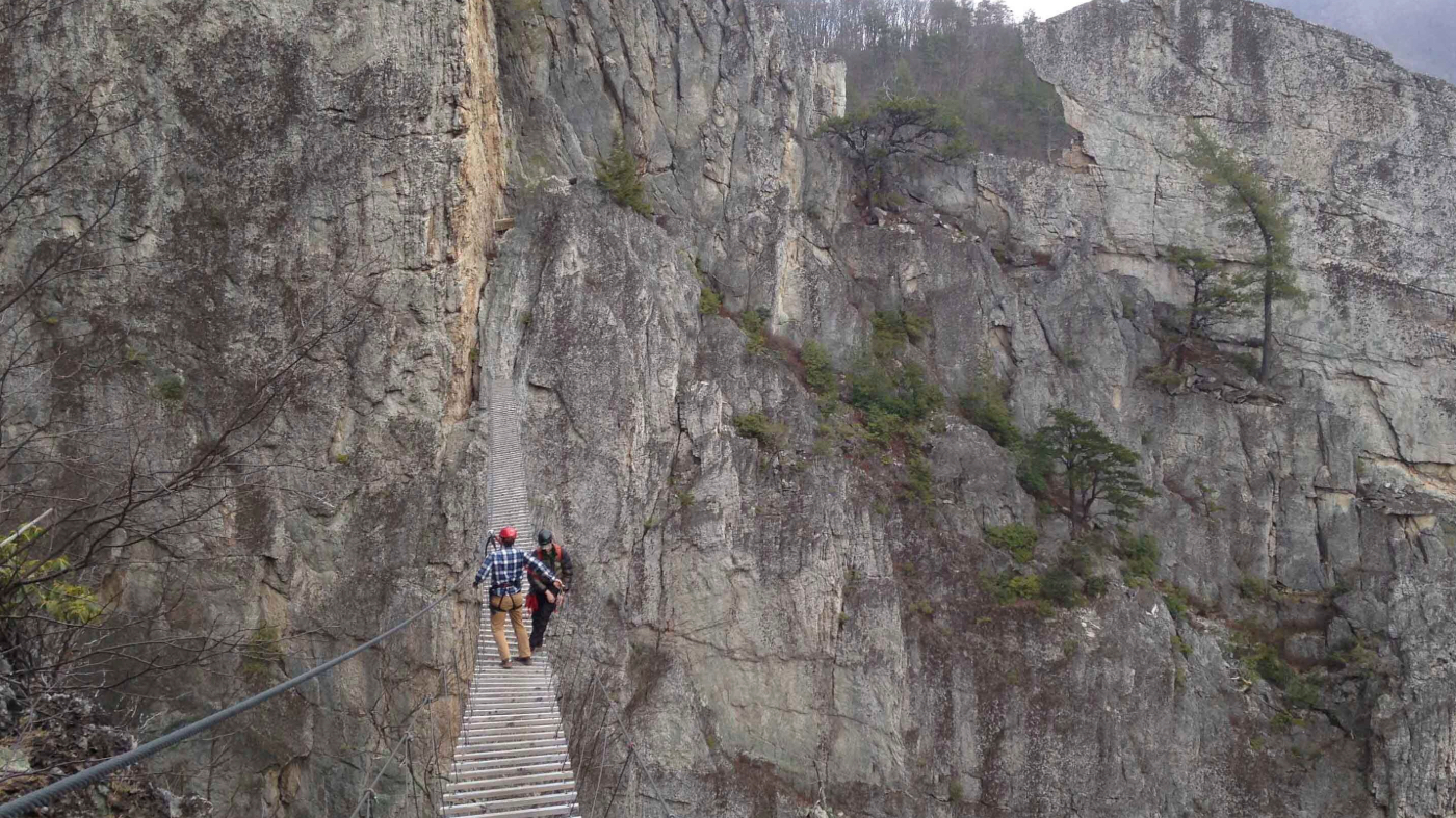 FILE – In this March 24, 2015 photo, Matt Karlson, right, supervisor for the NROCKS Outdoor Center and Chris Ward, operations manager for the center, walk across a suspension bridge that stretches 200 feet between rock formations at 150 feet above ground in Circleville, W.Va. (AP Photo/ Jonathan Drew, File)