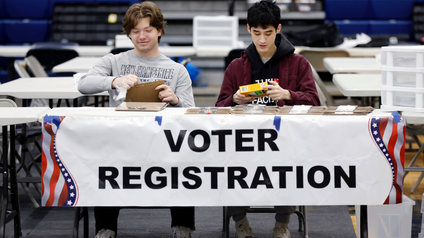 High school students Sawyer Brockman, left, and Jack Skilling volunteer at a voter registration table for the presidential primary election at Windham High School, Tuesday, Jan. 23, 2024, in Windham, N.H.
