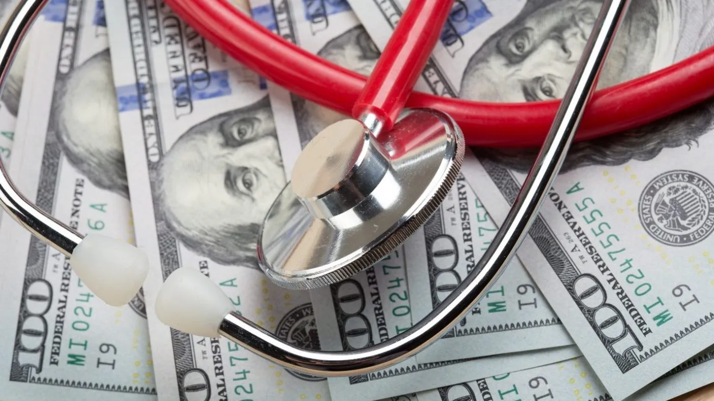 A stethoscope is seen on a pile of money.