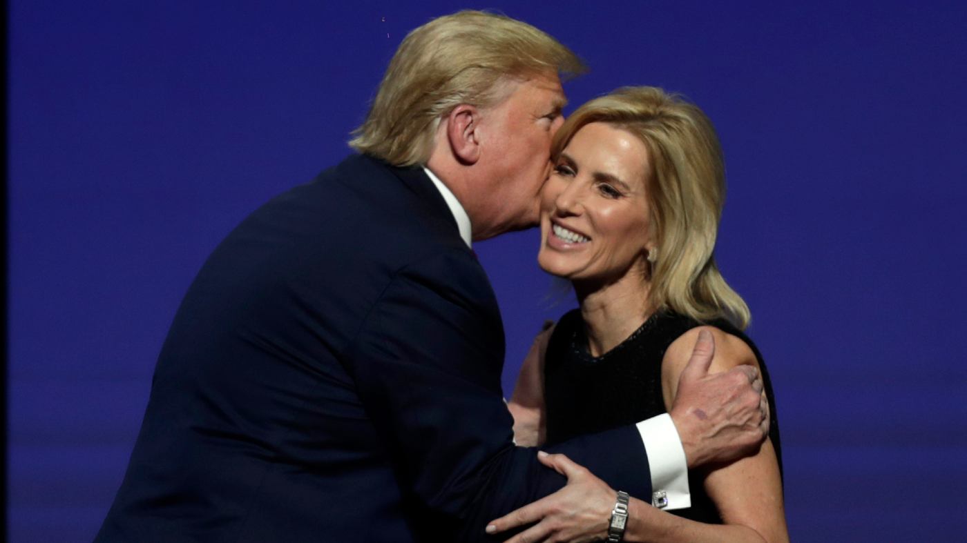 Then-President Trump gives Fox News host Laura Ingraham a kiss after inviting her on stage during the 2019 Turning Point USA Student Action Summit. (AP Photo/Luis M. Alvarez)