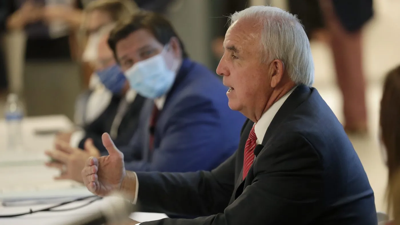 Then-Miami-Dade County Mayor Carlos Gimenez, right, speaks as Florida Gov. Ron DeSantis (R) looks on during a news conference at the old Pan American Hospital during the COVID-19 pandemic on July 7, 2020, in Miami.