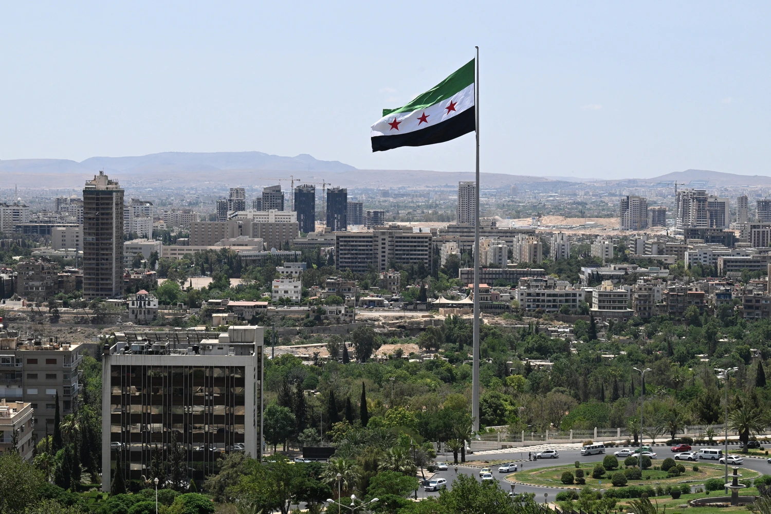 A large Syrian flag flutters above Tishreen Park in Damascus on June 4, 2025.