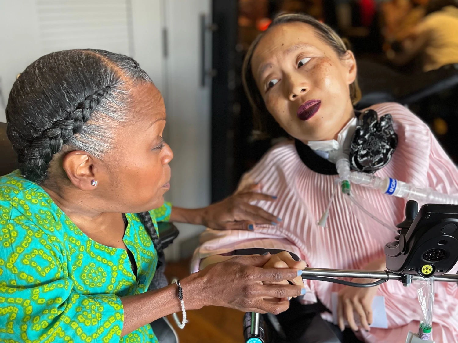 Yomi Young, left, speaks with Alice Wong at Wong's 50th birthday party in March 2024 in San Francisco.