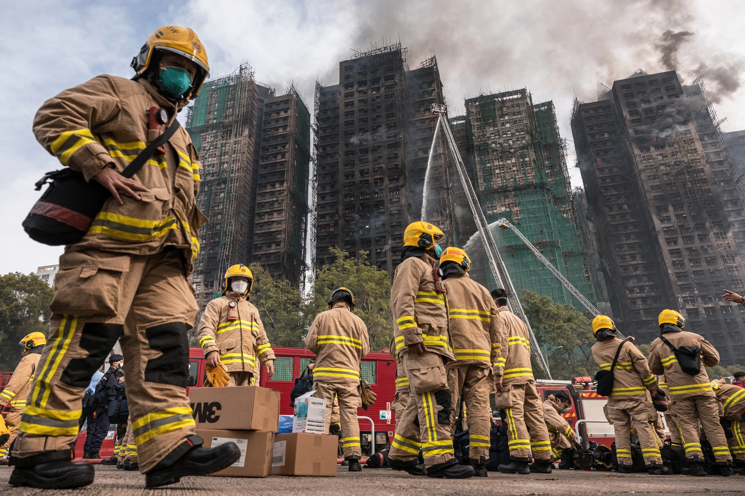 Firemen get ready after a major fire swept through several apartment blocks at the Wang Fuk Court residential estate in Hong Kong's Tai Po district on November 27, 2025.