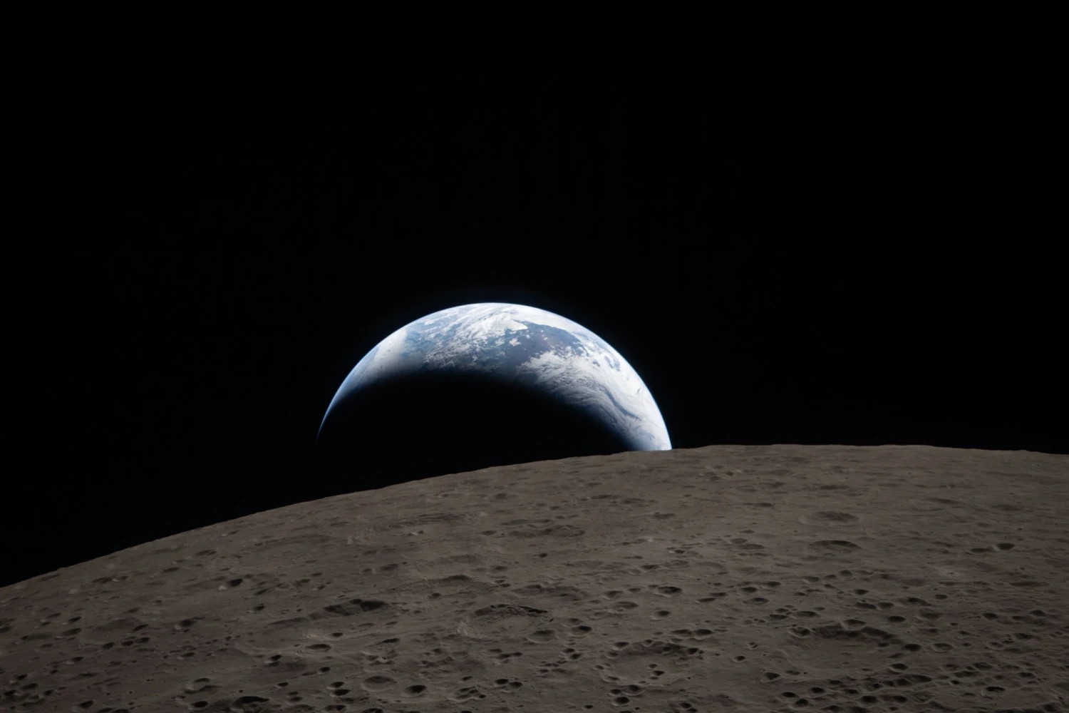 Earth dips beyond the lunar horizon in this first photo from the far side of the Moon captured from Orion on Monday, April 6, 2026.