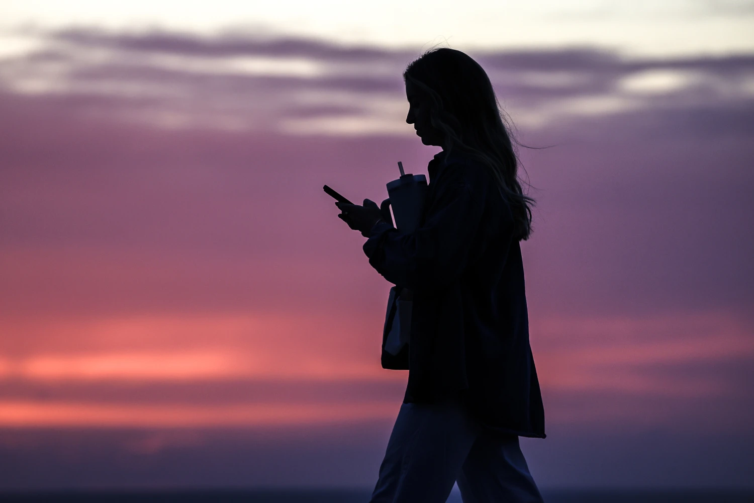 A woman looks down at a mobile phone on Feb. 6, 2026 in San Diego, Calif.