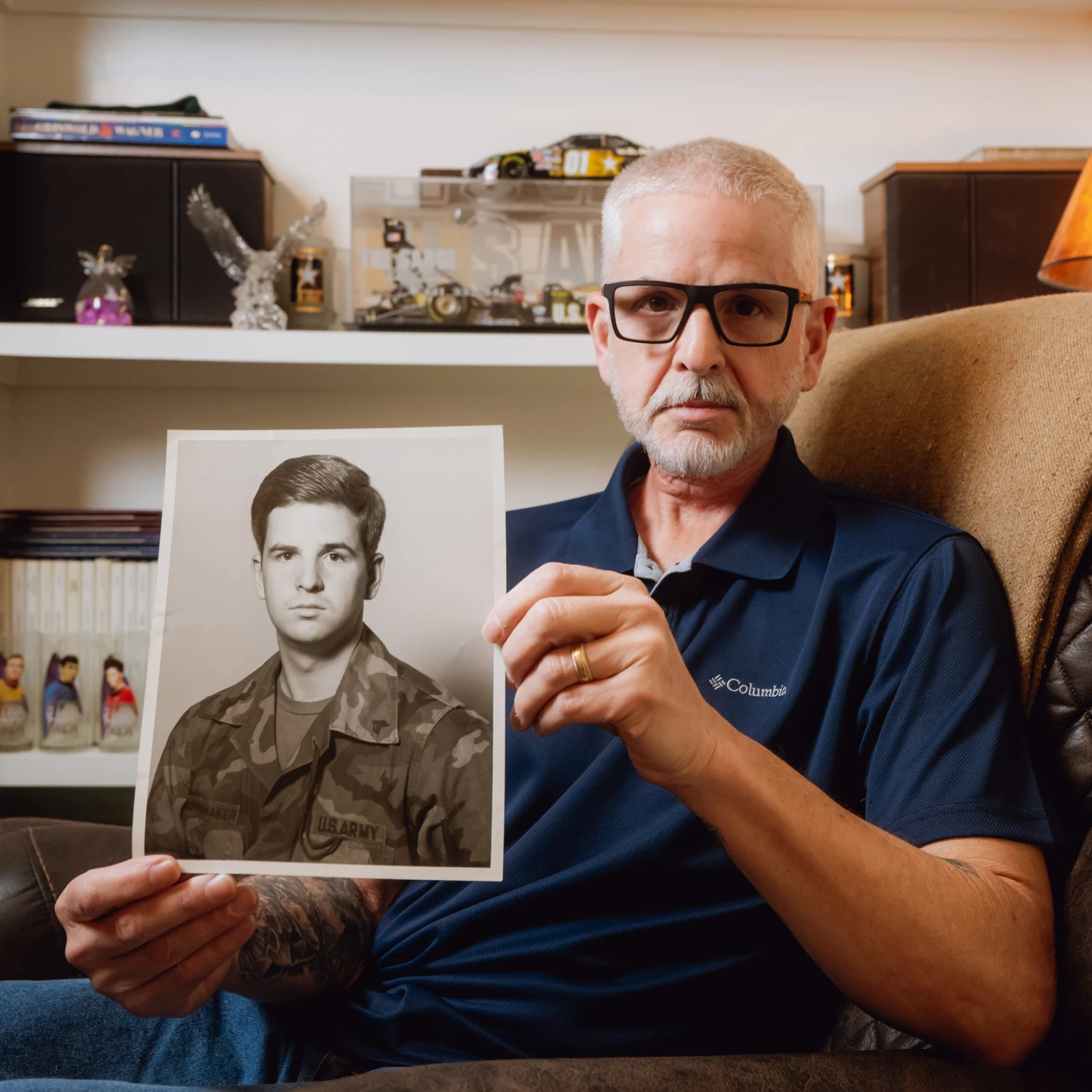 FORT WORTH, TEXAS - FEBRUARY 11, 2026: Guy Shoemaker, 64, displays his AIT platoon sergeant leadership photograph from his time as an Army recruiting officer at his home in Fort Worth, Texas, on Wednesday, Feb. 11, 2026. After his TRICARE plan transitioned to TriWest Healthcare Alliance, tens of thousands of dollars in previously approved claims for life-saving treatment and scans for his throat cancer were pulled back or denied because of a data error.