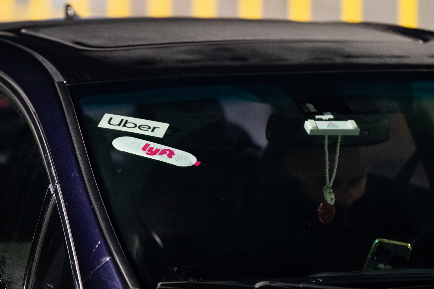 Lyft and Uber signage on a car at San Francisco International Airport (SFO) in San Francisco, California, US, on Thursday, Feb. 8, 2024.