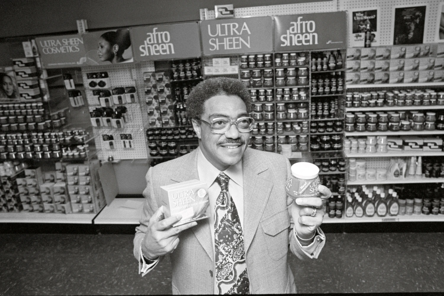 (Original Caption) Chicago: George E. Johnson a black entrepreneur with a high school education who parlayed a $250 investment into a company that grossed $39 million in sales, is seen in his office holding a few of the products made by Johnson Products Co., Inc. The firm is now the largest black manufacturing company in the world, with over 400 employees.