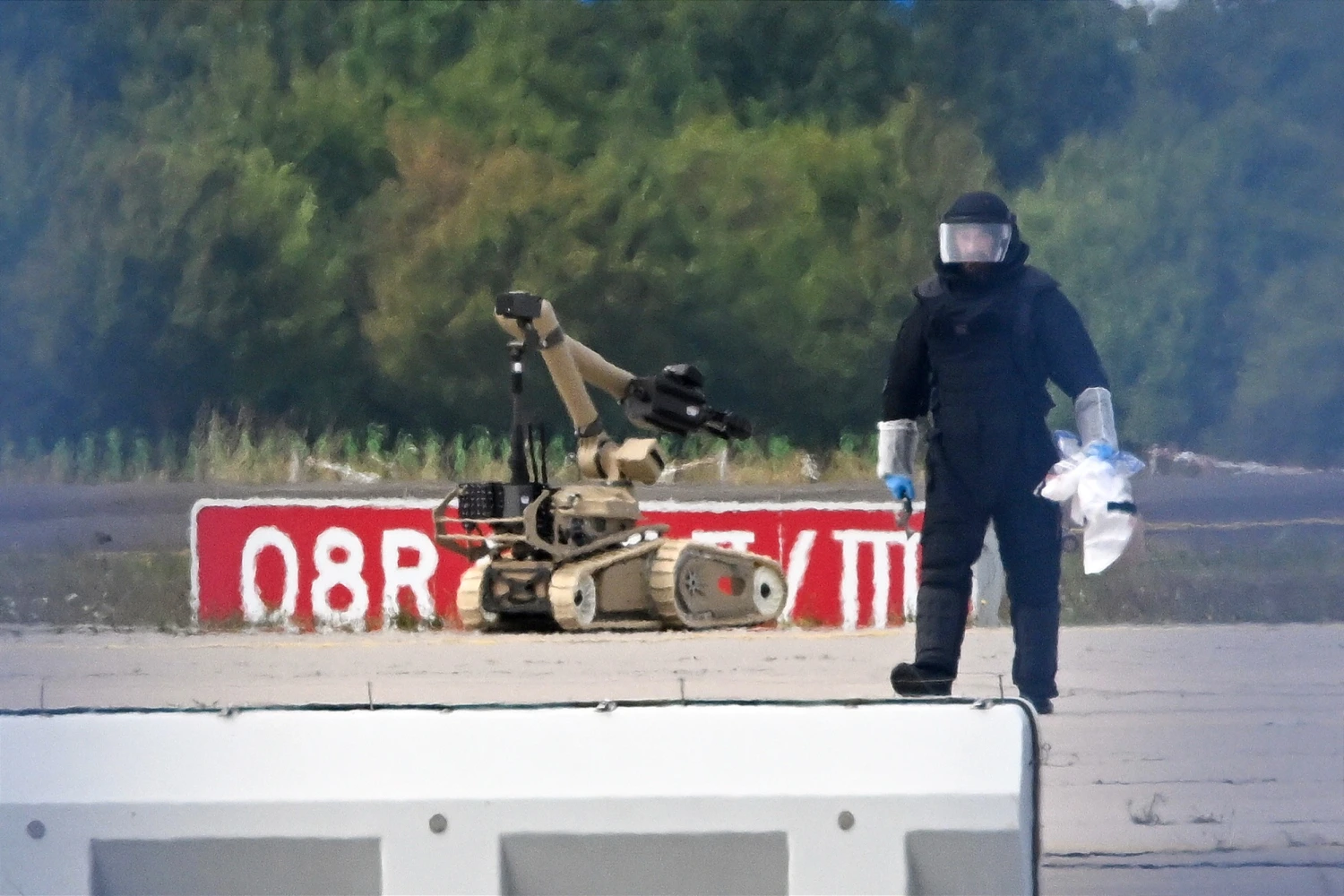 A forensic technician works alongside a bomb-disposal robot at Leipzig/Halle Airport, where a drone with an explosive device was found and a detonator was removed from the object, in Schkeuditz, Germany, on Aug. 5, 2026.