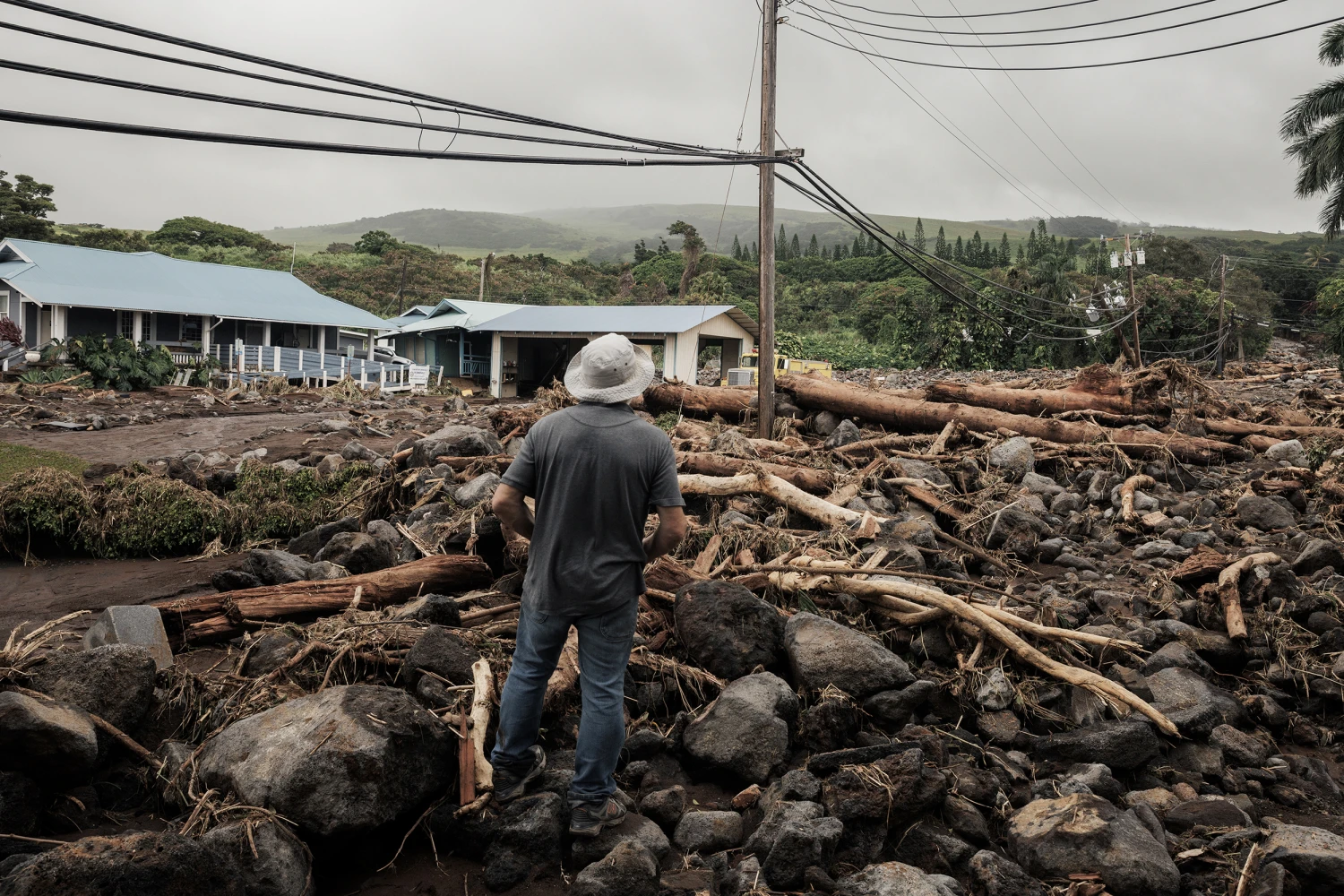 A man watches debris flow along Ka'alaiki Road after Hurricane Lala in Naalehu, Hawaii, Monday, Aug. 17, 2026.