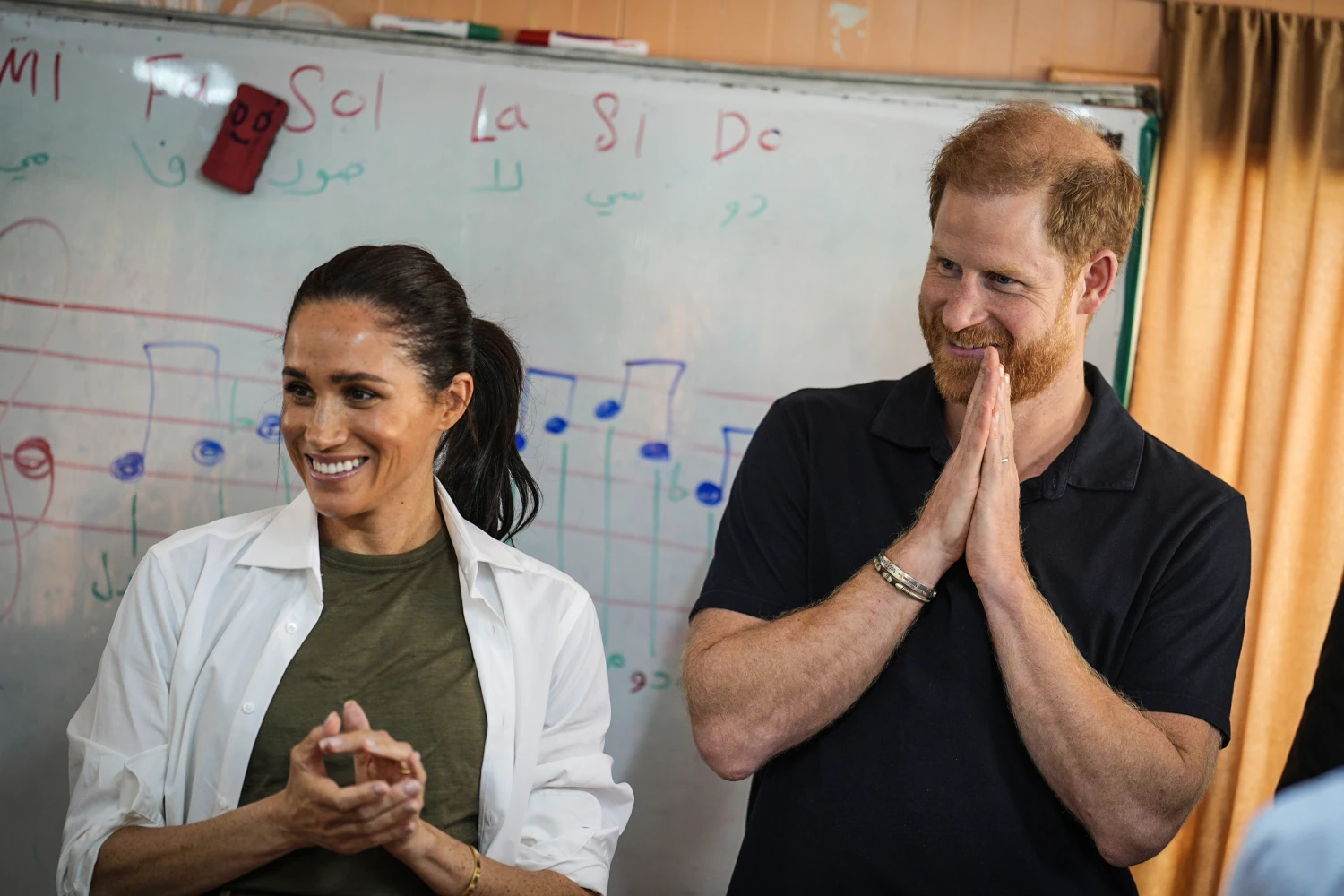 Meghan and Prince Harry, the Duchess and Duke of Sussex, listen to a music class at the QuestScope Youth Center at the Za'atari refugee camp near Mafraq in northern Jordan on Feb. 25. 