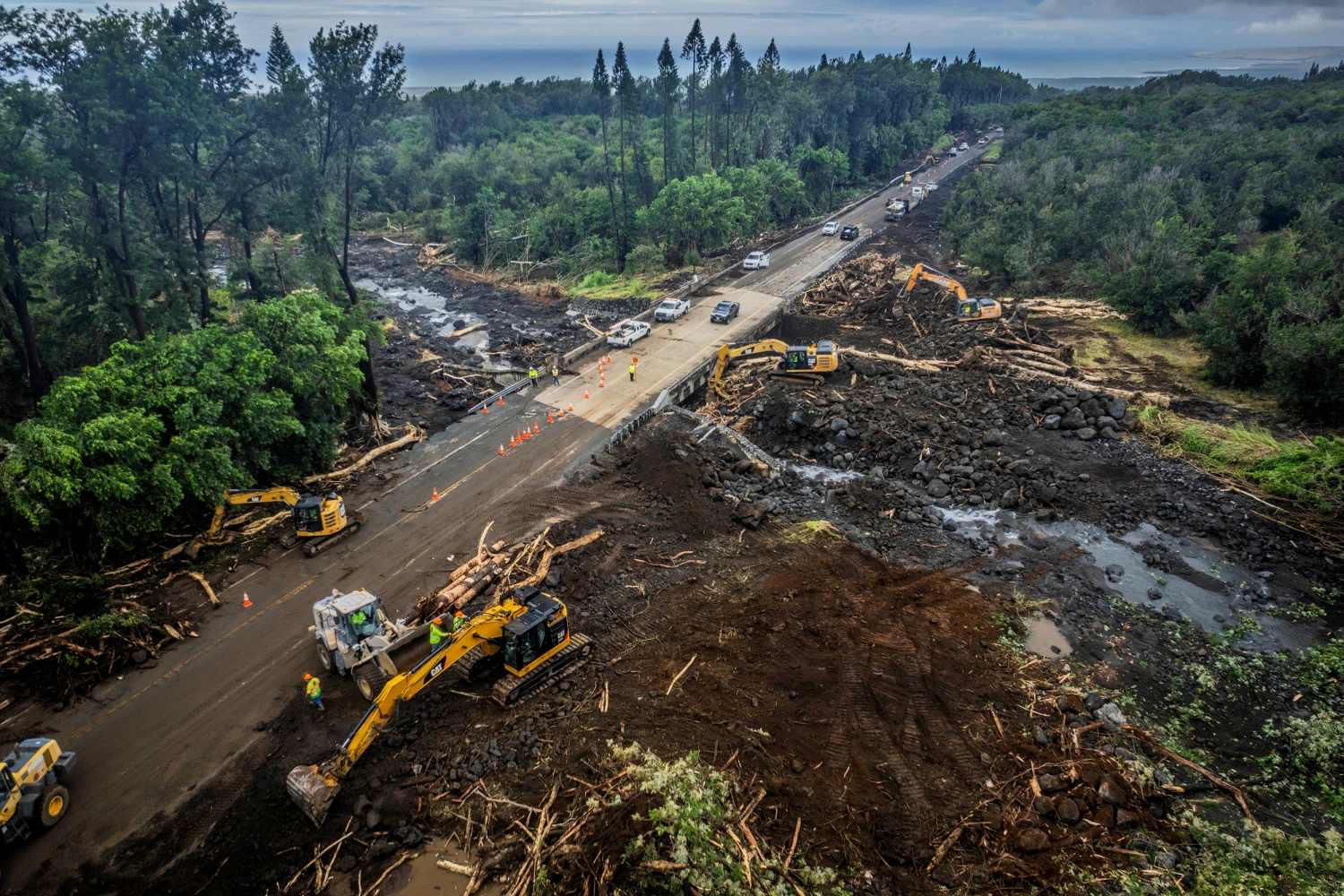 Road crews work to clear damage along Highway 11 outside of Pahala, on the Big Island of Hawaii.