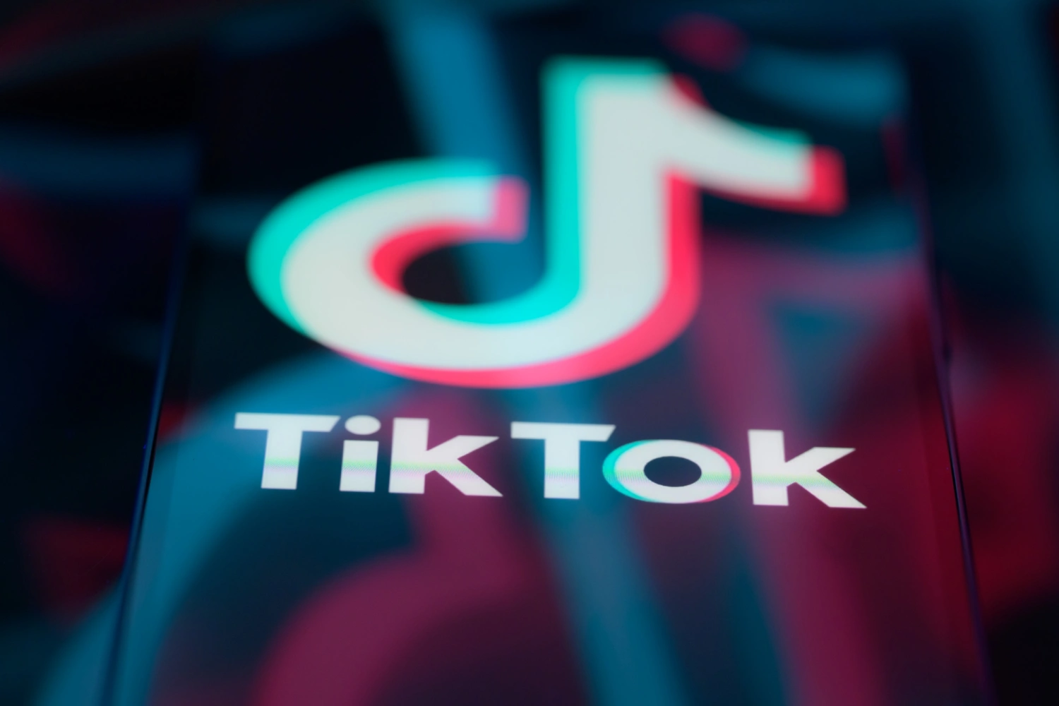 The TikTok logo is displayed on a smartphone screen.