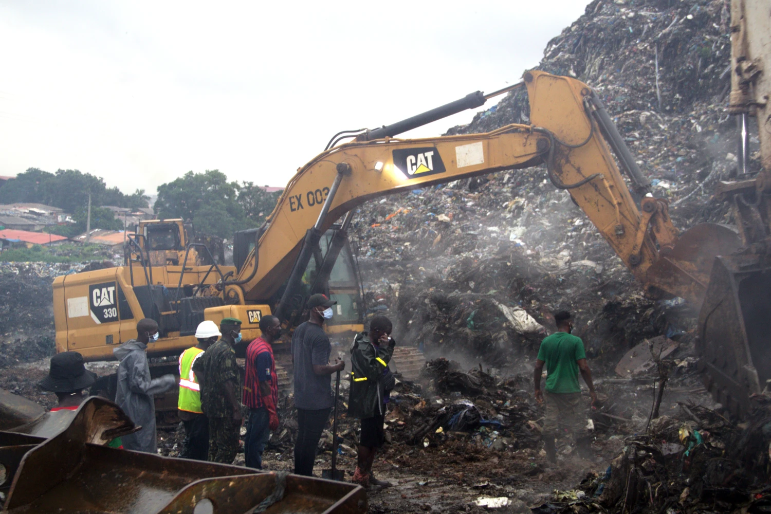 Rescue workers search through a heap of refuse after it collapsed at Conakry’s largest landfill, Guinea, Sunday, Aug. 23, 2026.