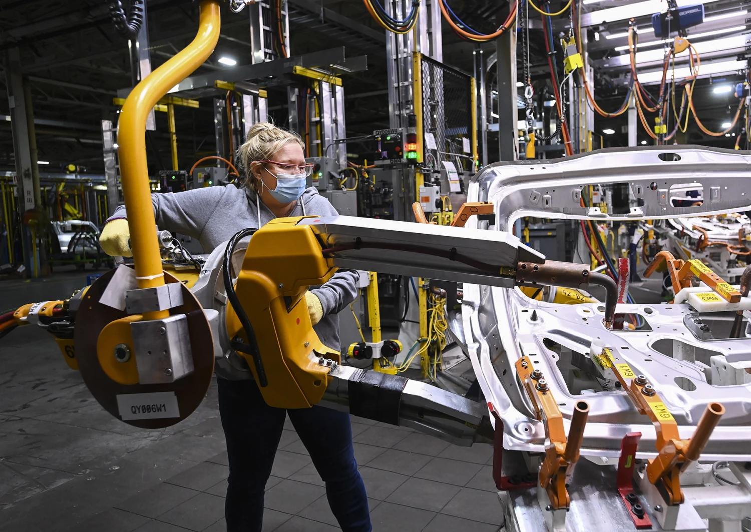 A workers welds vehicle doors at the General Motors assembly plant in Oshawa, Ontario, in 2021. 