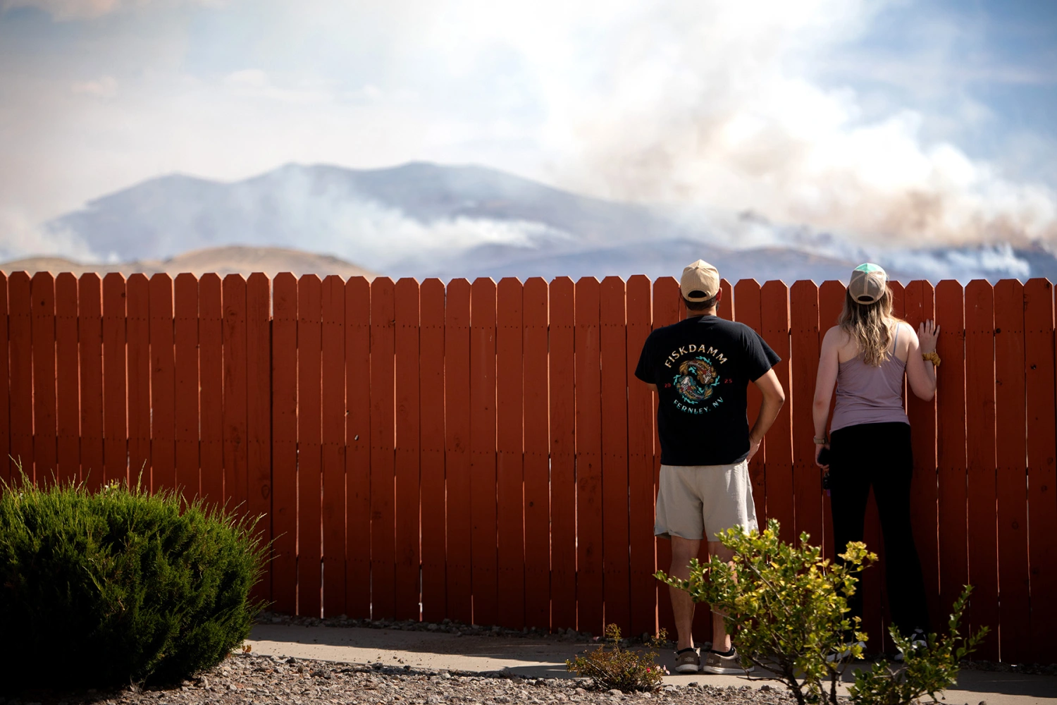 Residents watch the Hawk Fire burning Sunday in Reno, Nev.