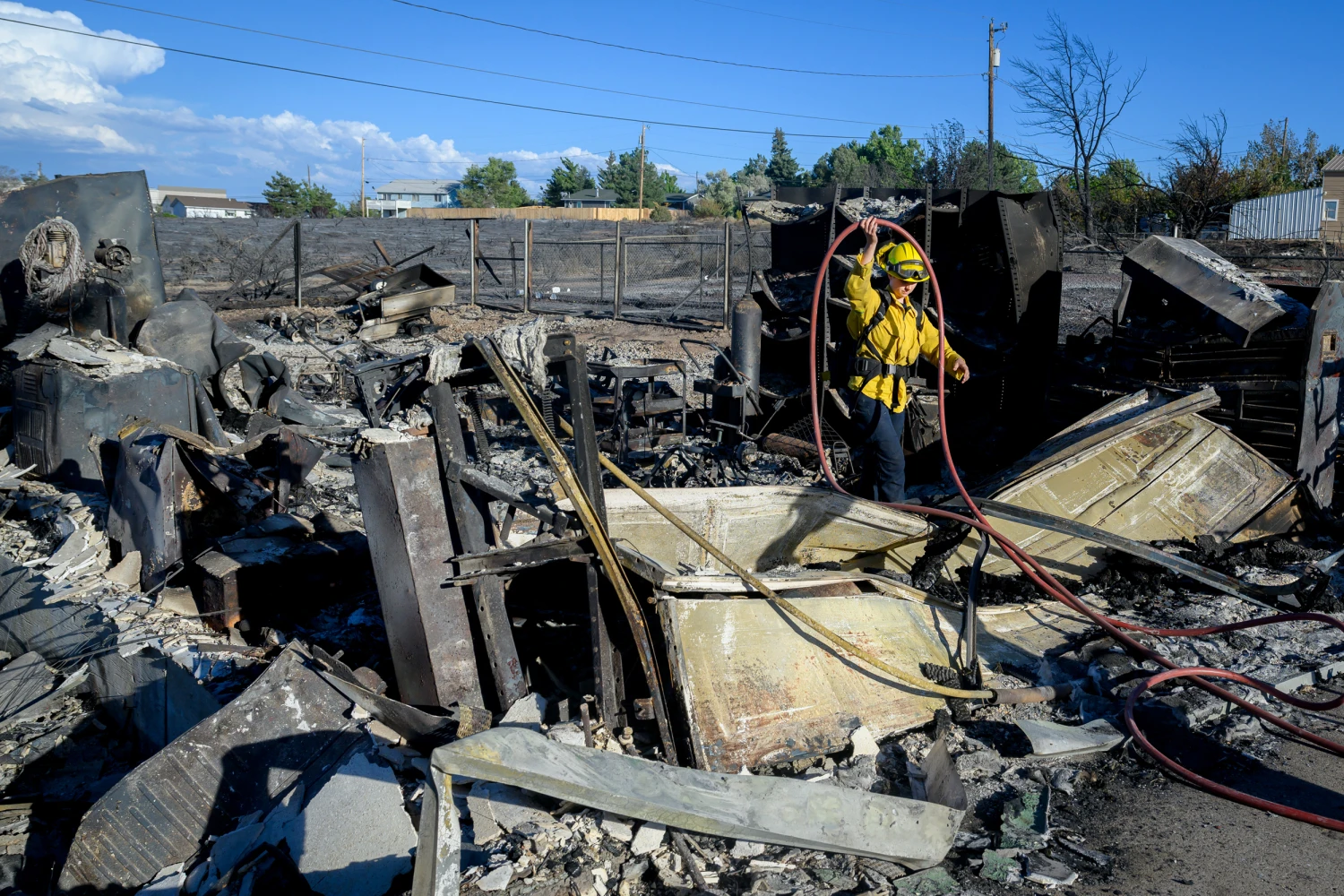 A firefighter works on the remains of a home burned by the Hawk Fire in Reno, Nevada on August 24, 2026.