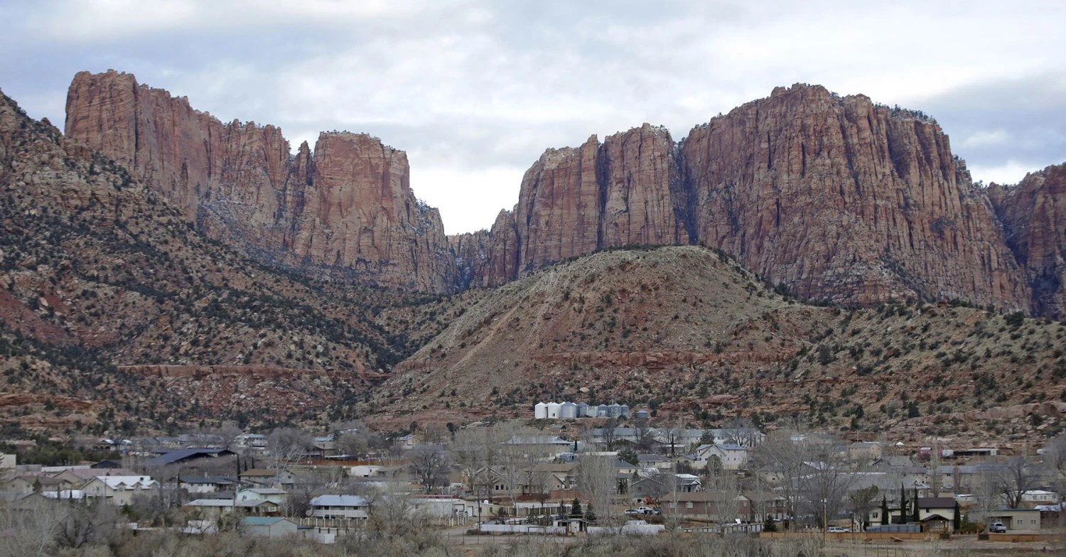 Hildale, Utah, sitting at the base of Red Rock Cliff mountains, with its sister city, Colorado City, Ariz., in the foreground in 2014. 