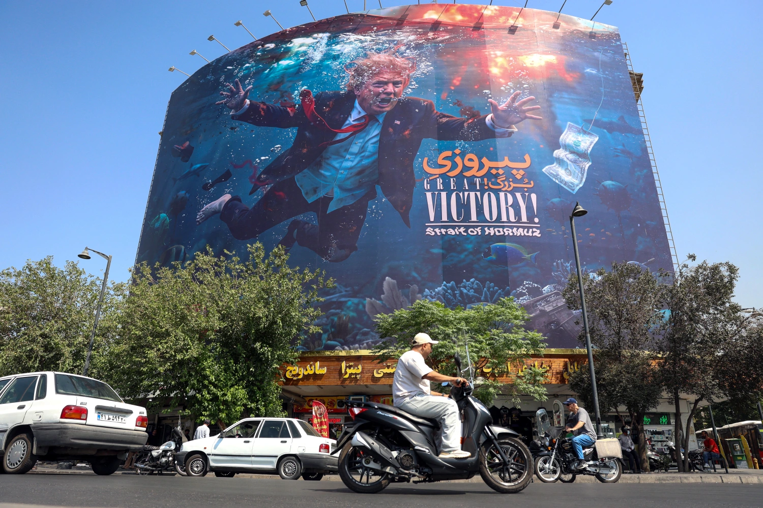 Motorists drive past an anti-U.S. billboard in Tehran on Aug. 24