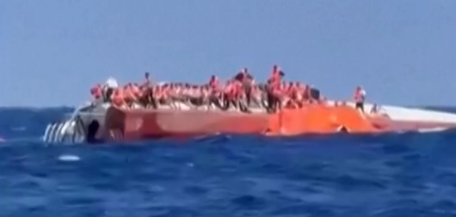 Passengers are seen standing on a capsized ship off northern Cyprus on Aug. 30 as they await rescue.