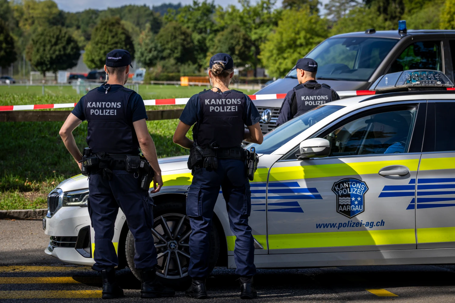 Police officers secure the area around the Schachen horse racing track following a shooting at a rave, in Aarau, Switzerland on Aug. 30.